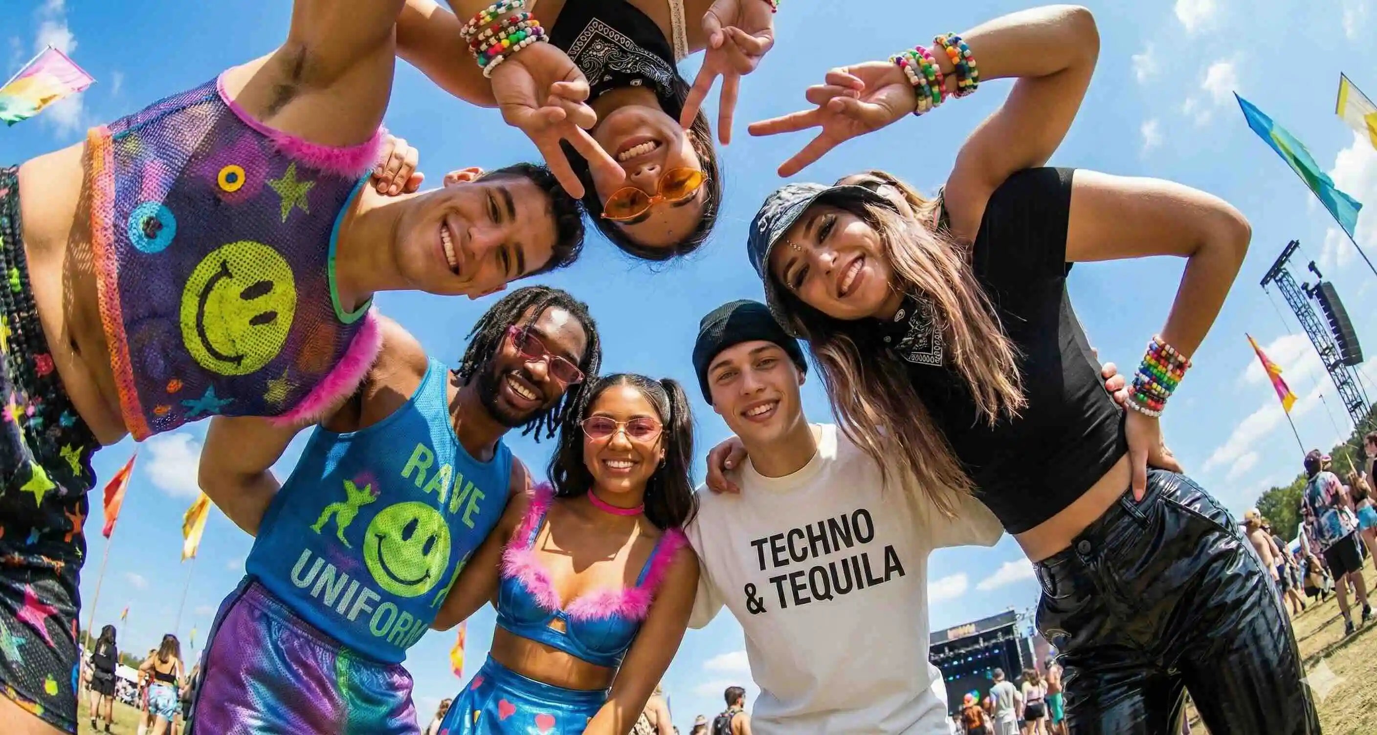 Group of people smiling at and standing in a circle wearin rave uniform clothes